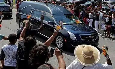 Well-wishers have been throwing flowers onto the hearse