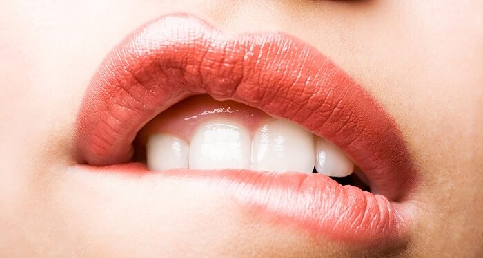a woman biting lip in pain