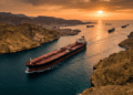 Aerial view of an oil tanker transiting the Strait of Hormuz chokepoint, illustrating the critical global energy shipping route during a dramatic sunset.