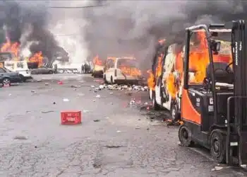 Smoke rises from torched vehicles during Eastern Cape violence over Nigerian king installation.