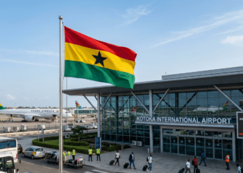 Ghana national flag flying at an international airport terminal.