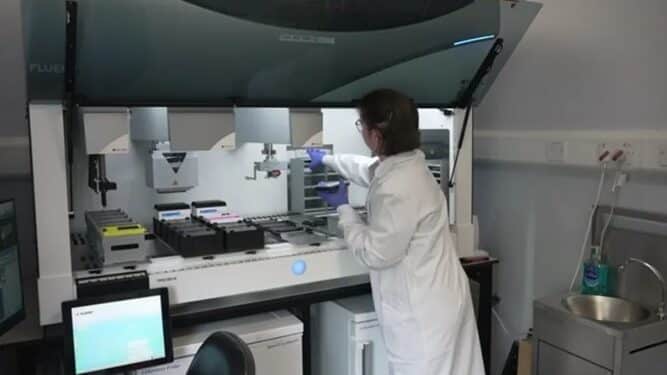 Scientist in Edinburgh laboratory using AI in neurological research to analyze stem-cell-derived brain neurones for motor neurone disease treatment.
