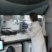 Scientist in Edinburgh laboratory using AI in neurological research to analyze stem-cell-derived brain neurones for motor neurone disease treatment.