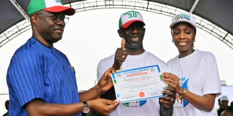 Governor Seyi Makinde speaking at the Allied Peoples Movement Oyo primary elections ahead of the Oyo State 2027 elections, with Bimbo Adekanmbi receiving his governorship certificate of return from APM party executives in Ibadan.