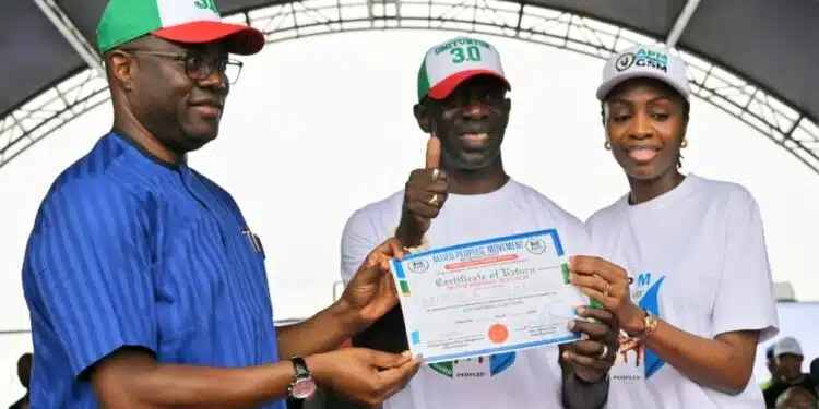 Governor Seyi Makinde speaking at the Allied Peoples Movement Oyo primary elections ahead of the Oyo State 2027 elections, with Bimbo Adekanmbi receiving his governorship certificate of return from APM party executives in Ibadan.