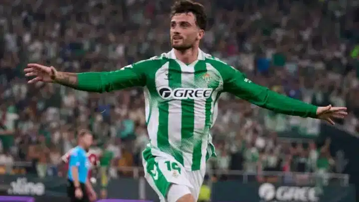 Real Betis' Troy Parrott celebrates after scoring against Real Madrid as Kylian Mbappé looks on during a dramatic LaLiga match.