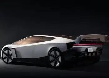 Futuristic silver Tesla Roadster concept hovering above a platform with rocket-like thrusters and dramatic red lighting.